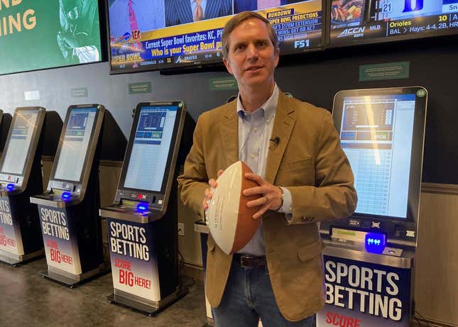 Kentucky Gov. Andy Beshear stands in front of sports betting kiosks at Churchill Downs in Louisville, Ky., Thursday, Sept. 7, 2023. The Democratic governor placed the first sports bet Thursday at Churchill Downs, home of the Kentucky Derby. It fulfilled a pledge that his administration would launch sports wagering in time for the NFL season. (AP Photo/Bruce Schreiner)