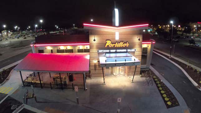 A drone photo of a Portillo's Restaurant at night. 