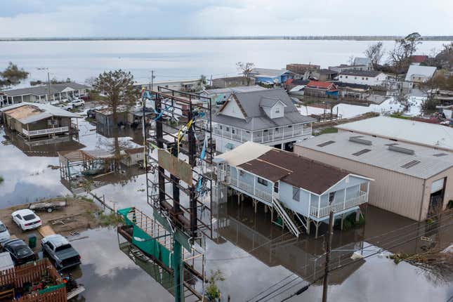 FILE - Flood waters surround storm damaged homes on Aug. 31, 2021, in Lafourche Parish, La., as residents try to recover from the effects of Hurricane Ida. Attorneys for 10 states and numerous Louisiana local governments are hoping a federal judge will block a new system for calculating rates for federal flood insurance. Arguments were being heard Thursday, Sept. 14, 2023 in New Orleans federal court over rates that the government began phasing in in 2021. (AP Photo/Steve Helber)