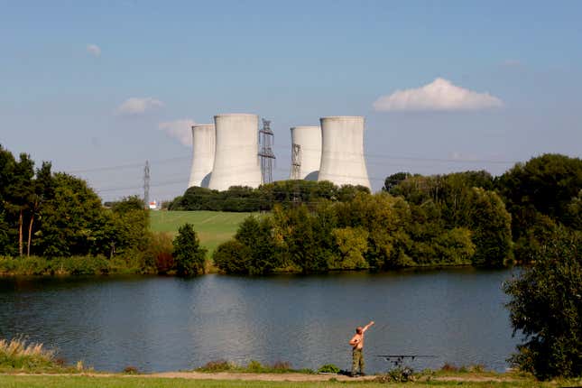 FILE - A man fishes with the towering Dukovany nuclear power plant in the background, in Dukovany, Czech Republic, Sept. 27, 2011. The Czech government said on Wednesday Jan. 31, 2024, it was expanding a public tender to build up to four nuclear reactors instead of one as the country&#39;s strives to become more energy independent and wean itself of fossil fuels.(AP Photo/Petr David Josek, File)