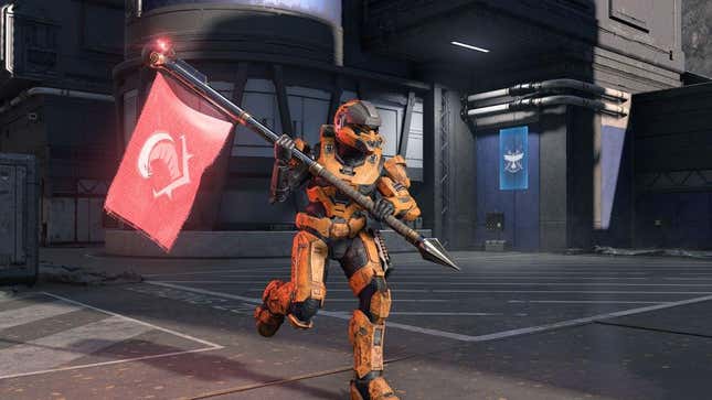 A Spartan in an orange power armor runs with a flag in Halo Infinite.