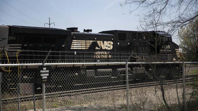 A black train engine with the Norfolk Southern logo (a horse running towards the letters N and S) on a train track in Columbus Ohio on a winter day.