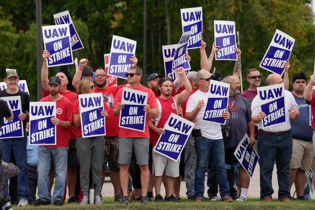 FILE - United Auto Workers members hold picket signs near a General Motors assembly plant in Delta Township, Mich., Sept. 29, 2023. About 46,000 United Auto Workers at GM are expected to wrap up voting on a tentative contract agreement in a close race that will decide the fate of the deal that ended a six-week strike. The union is expected to announce GM results Thursday evening. (AP Photo/Paul Sancya, File)