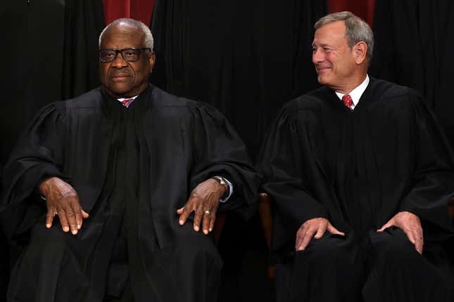 WASHINGTON, DC - OCTOBER 07: United States Supreme Court Associate Justice Clarence Thomas (L) and Chief Justice of the United States John Roberts (R) pose for their official portrait at the East Conference Room of the Supreme Court building on October 7, 2022 in Washington, DC