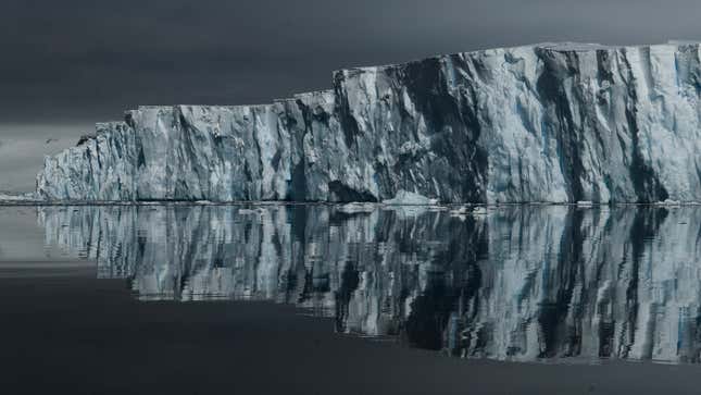 The front of Thwaites Glacier, including its reflection in the surrounding ocean.