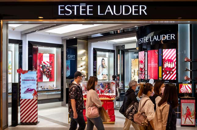 Des piétons passent devant un magasin Estée Lauder à Hong Kong. 