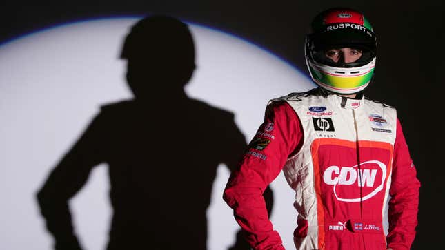 A photo of British racer Justin Wilson in a red fire suit. 