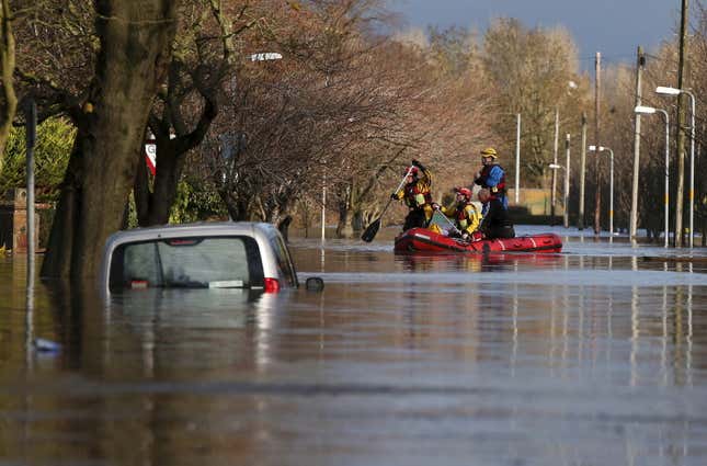 Rescue workers remove local residents by boat from a flooded residential street in Carlisle, Britain December 6, 2015. British police have declared a major incident in northern England after prolonged heavy rain caused widespread flooding and forced emergency services to evacuate residents from their homes. REUTERS/Phil Noble