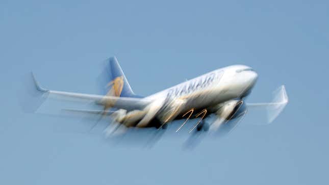 A blurry photo of a Ryanair plane in the air.