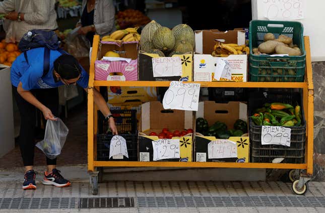 A customer buys aubergines at a fruit store in Ronda, Spain, June 13, 2023.