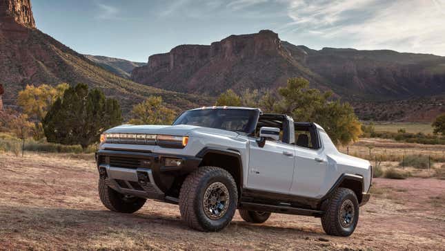 A Hummer EV with the roof open on dirt