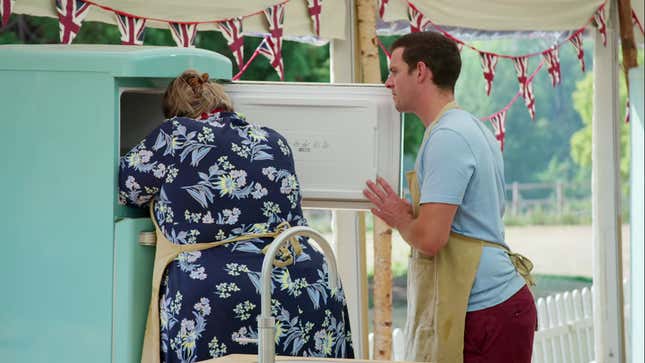 Laura with her head and shoulders inside the freezer while Dave looks on, concerned