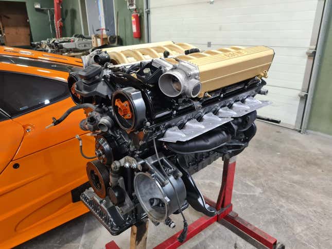 Photo of a BMW V12 engine beside the Porsche Boxster-based McLaren F1 LM replica.
