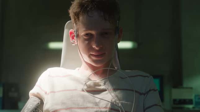 Luke sits in a chair, with wires attached to his head.
