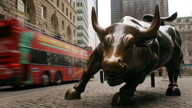 A tour bus passes the Wall Street bull