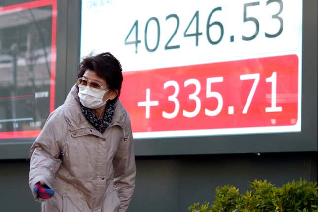 A person walks in front of an electronic stock board showing Japan&#39;s Nikkei 225 index at a securities firm Monday, March 4, 2024, in Tokyo. Japan&#39;s Nikkei 225 share benchmark has topped 40,000 for the first time as strong demand for technology shares keeps pushing the index higher.(AP Photo/Eugene Hoshiko)