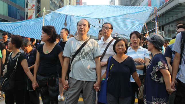 Hong Kong democracy demonstrators form a chain to protect their protest site in Mong Kok.