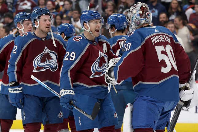 DENVER, COLORADO - DECEMBER 11: Nathan MacKinnon #29 of the Colorado Avalanche celebrates with goalie Ivan Prosvetov #50 after their win against the Calgary Flames at Ball Arena on December 11, 2023 in Denver, Colorado. (Photo by Matthew Stockman/Getty Images)