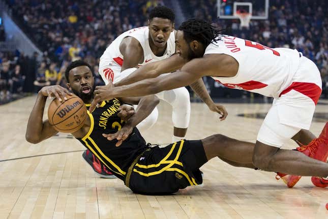 7. Januar 2024;  San Francisco, Kalifornien, USA;  Der Stürmer der Golden State Warriors, Andrew Wiggins (22), und der Stürmer der Toronto Raptors, Immanuel Quickley (5), und der Stürmer RJ Barrett (9), kämpfen in der ersten Halbzeit im Chase Center um den Ballbesitz.