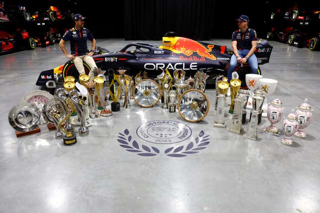 Sergio Pérez de México y Oracle Red Bull Racing (L) y Max Verstappen de Países Bajos y Oracle Red Bull Racing posan para  foto con trofeos durante el regreso a casa de Max y Checo en Red Bull Racing Factory el 13 de diciembre de 2023 en Milton Keynes, Inglaterra