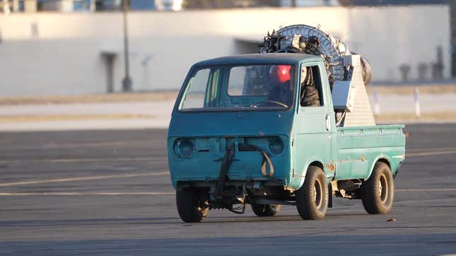 A photo of a kei truck with a jet engine on the back. 