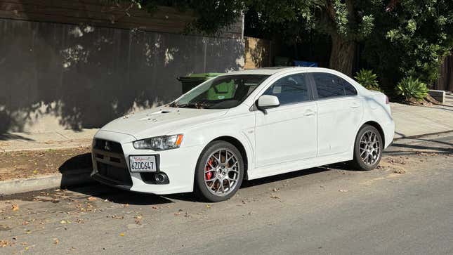 Front 3/4 view of a white Mitsubishi Lancer Evolution X parked on the street