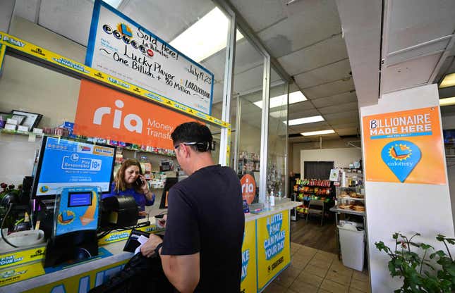 A customer makes a purchase at Las Palmitas mini market, decorated with a ‘Billionaire Made here’ sign, where the winning July 19-drawn lottery ticket was sold on July 20, 2023 in Los Angeles, California.