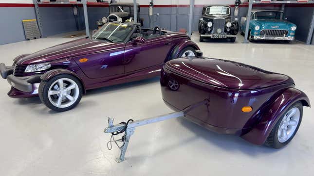 A photo of the purple prowler and its detached trailer parked in a garage