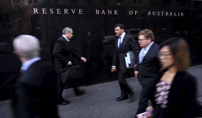 des gens marchent devant la Banque de réserve d’Australie