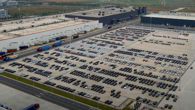 A parking lot full of new Teslas in black and white