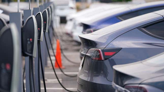 This Aug. 23, 2020 photo shows a long line of unsold 2020 models charge outside a Tesla dealership in Littleton, Colo. 