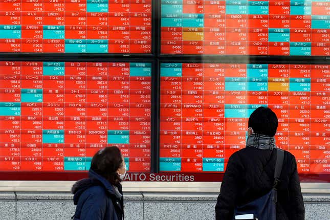 FILE - People look at an electronic stock board showing Japan&#39;s stock prices at a securities firm in Tokyo, on Jan. 17, 2024. Asian stocks were mixed Wednesday, Feb. 21, 2024 after technology stocks led Wall Street broadly lower on Tuesday, with investors waiting for chipmaker Nvidia&#39;s quarter earning report. (AP Photo/Eugene Hoshiko, File)