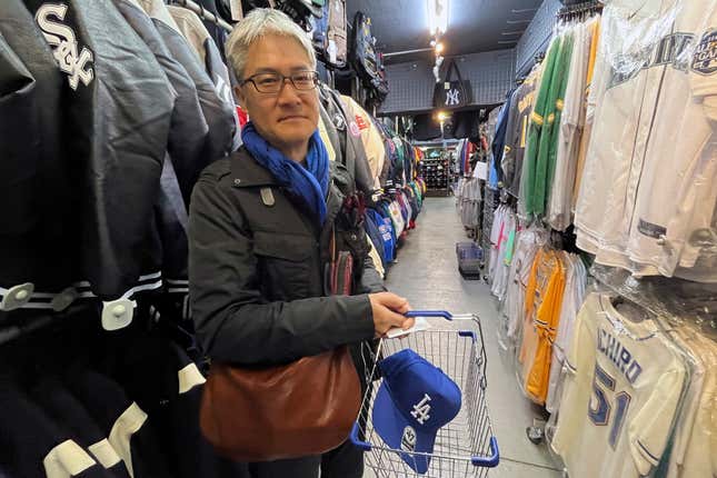 Hideki Chiba has a blue Dodgers cap in his basket, a gift for his father-in-law, as he shops on Monday Feb 26, 2024, at a sporting goods store, &quot;SELECTION,&quot; in Shinjuku district in Tokyo. (AP Photo/Stephen Wade)