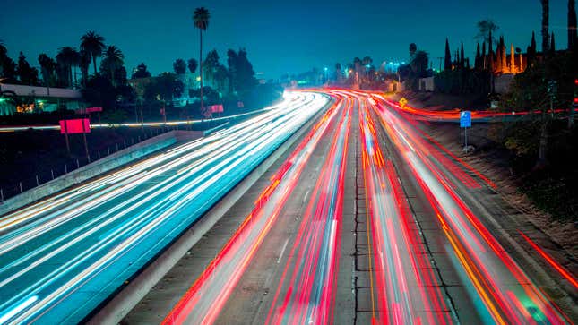 A long exposure photo of car tail lights snaking along a highway. 