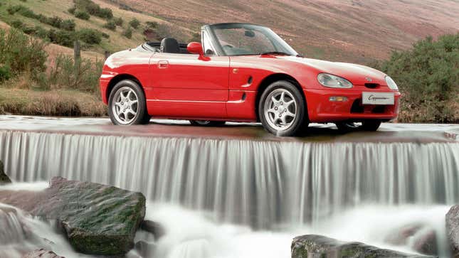 A red Suzuki Cappuccino roadster on top of a waterfall