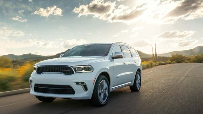 Une Dodge Durango blanche circulant dans le désert devant un coucher de soleil