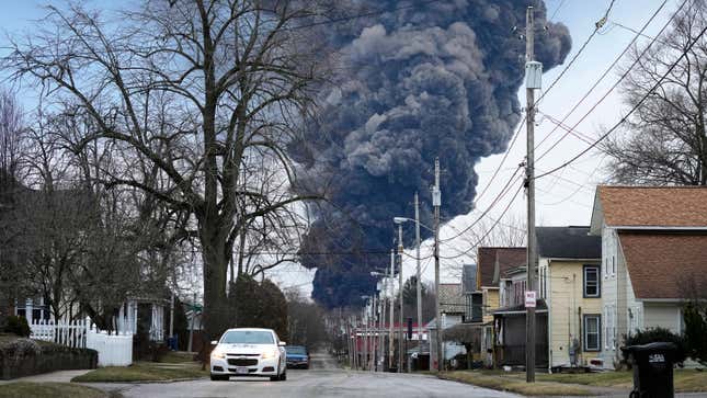 A black plume rises over East Palestine, Ohio, as a result of a controlled detonation of a portion of the derailed Norfolk Southern trains, Feb. 6, 2023. On Thursday, June 29, the railroad industry filed suit to block a new minimum crew-size requirement that Ohio imposed after a fiery train derailment in East Palestine in February. 