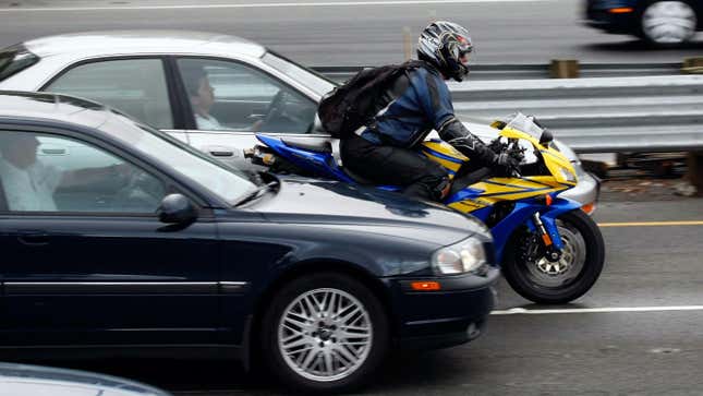 A motorcyclist rides between cars in slow moving traffic on Highway 101 October 16, 2007 in Corte Madera, California