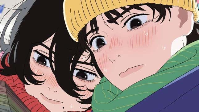 Two young girls lean into each other as they read manga