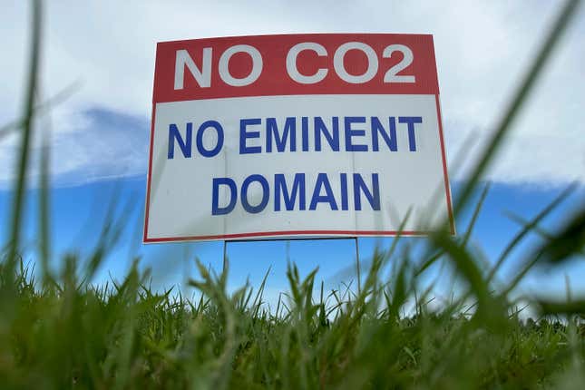 A sign reading &quot;No CO2, no eminent domain&quot; stands along a rural road east of Bismarck, N.D., on Aug. 15, 2023. One of the two biggest proposed carbon dioxide pipeline projects in the Midwest is being put on hold so the company can reevaluate the route. Navigator CO2 Ventures has withdrawn its application for a permit in Illinois. And it said in a statement Tuesday, Oct. 10 that it was putting all its permit applications on hold while it reassesses the project&#39;s route through South Dakota, Nebraska, Iowa, Minnesota and Illinois. (AP Photo/Jack Dura, file)