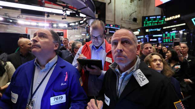 People look on at the New York Stock Exchange on the day of Reddit’s initial public offering