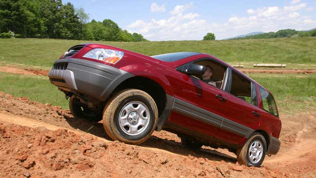 A photo of a red Honda Pilot SUV driving up mud. 