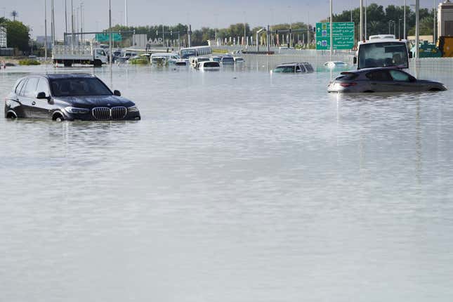 Vehicles sit abandoned in floodwater covering a major road in Dubai, United Arab Emirates, Wednesday, April 17, 2024.