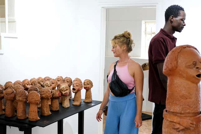 A lady looks at a sculpture piece during Lilian Nabulime&#39;s &quot;Olugamba exhibition at Xenson Art Space in Kamwokya, Kampala, the capital of Uganda, on Tuesday Nov.28 2023. Lilian Nabulime hasn&#39;t forgotten the time in the 1990s when the Ugandan capital had just one commercial art gallery, a small space that emerging artists struggled to get into. Now there are at least six in Kampala, including one whose curators recently exhibited the sculptor&#39;s contrarian work. (AP Photo/Hajarah Nalwadda.)