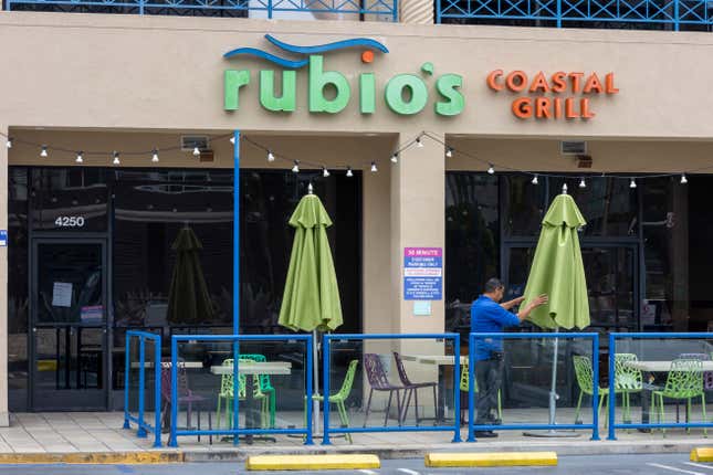 Building Manager closes the umbrellas at Rubio’s Costal Grill on Lincoln Blvd in Los Angeles, CA.