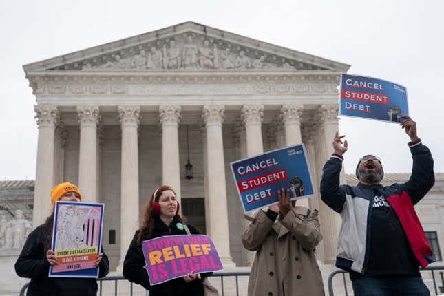 Supporters of student loan debt relief hold signs as they rally in front of the US Supreme Court.