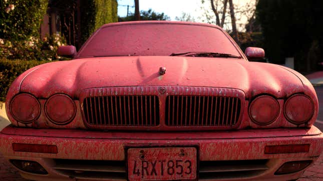 Fire retardant covers a Jaguar car after being dropped from a firefighting aircraft battling the Palisades Fire on January 11, 2025 in Los Angeles, California.