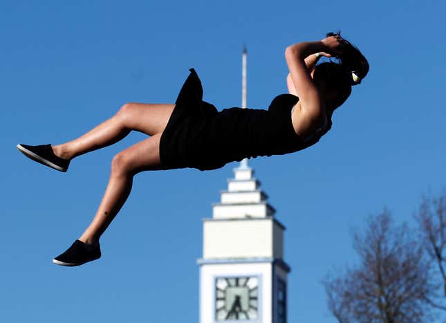 A woman dives from a platform into a giant air bed at a festival for the Rugby World Cup in New Zealand.