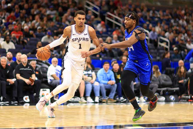 ORLANDO, FLORIDA - FEBRUARY 08: Victor Wembanyama #1 of the San Antonio Spurs drives on  Wendell Carter Jr. #34 of the Orlando Magic during a game  at Kia Center on February 08, 2024 in Orlando, Florida. (Photo by Mike Ehrmann/Getty Images) NOTE TO USER: User expressly acknowledges and agrees that, by downloading and or using this photograph, User is consenting to the terms and conditions of the Getty Images License Agreement. (Photo by Mike Ehrmann/Getty Images)