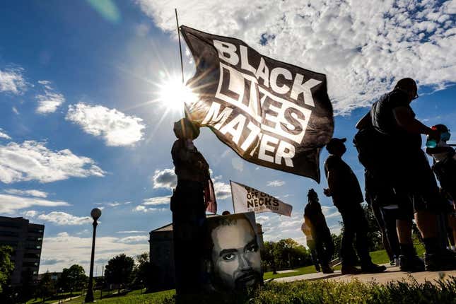 A woman holds a Black Lives Matter flag during an event in remembrance of George Floyd and to call for justice for those who lost loved ones to the police violence outside the Minnesota State Capitol on May 24, 2021 in Saint Paul, Minnesota.